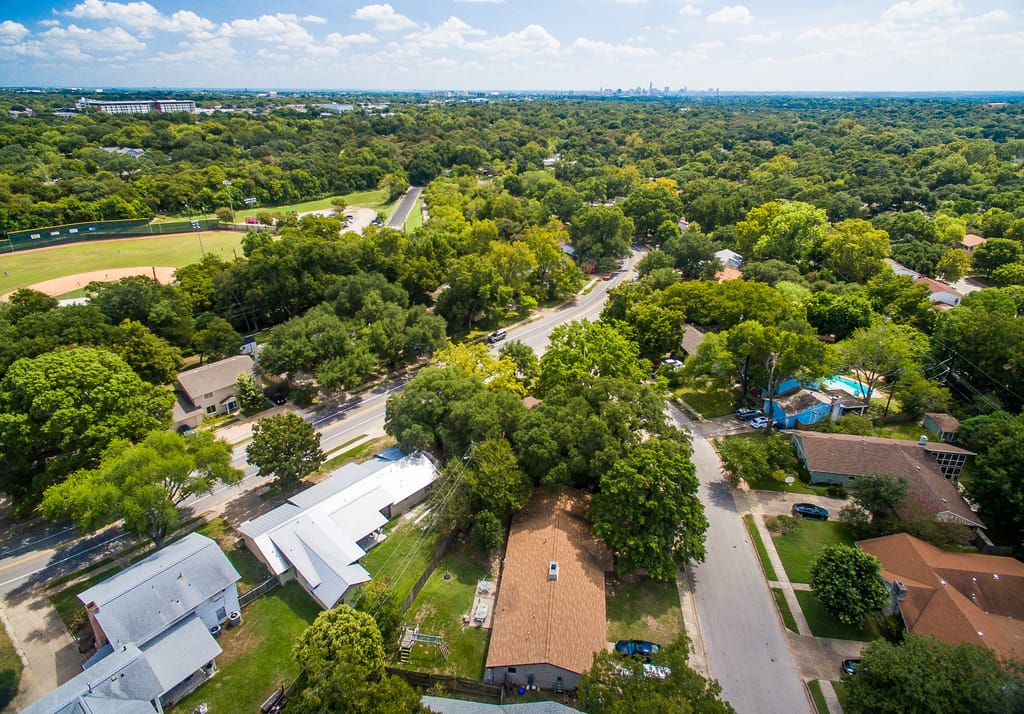 A shaded residential street of family homes in north central Austin.