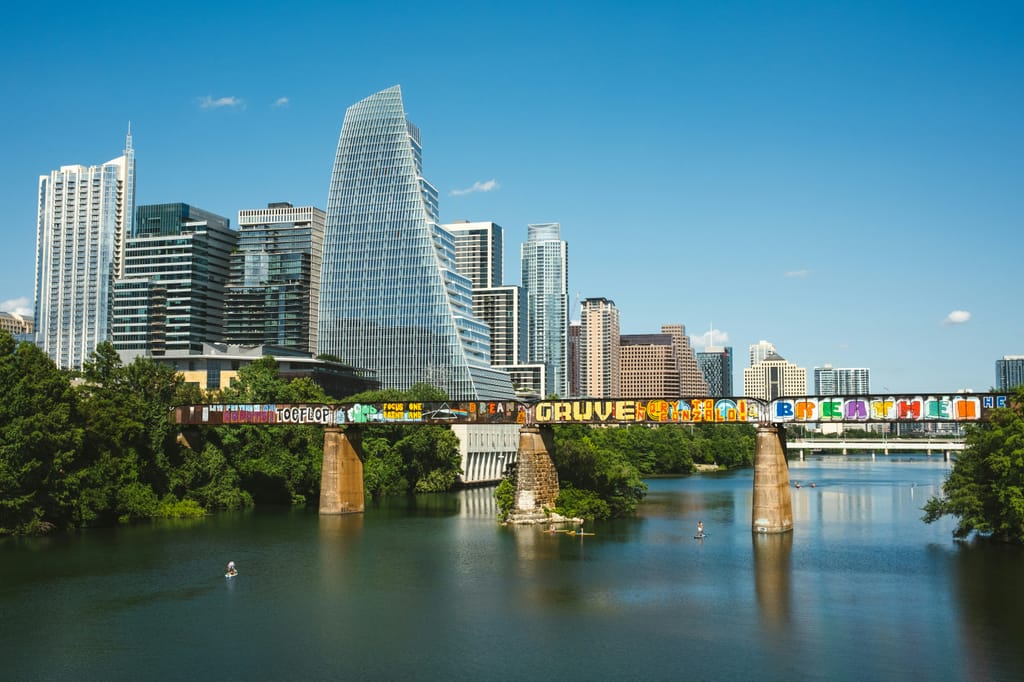 Downtown Austin towers rising above the tree line at golden hour.