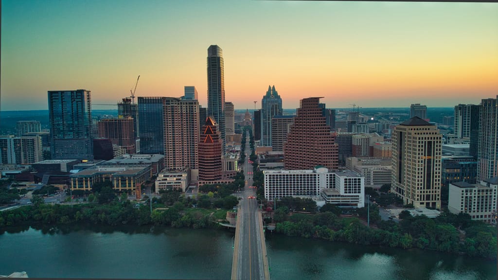 Austin neighborhoods and tree canopy seen from above at golden hour.