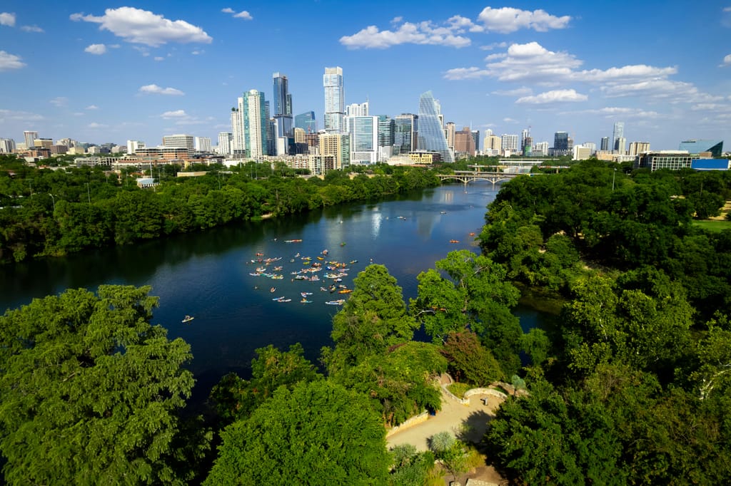 Downtown Austin towers above the river on a clear afternoon.
