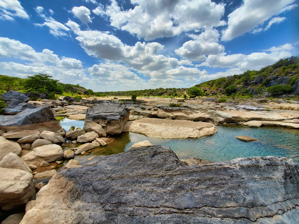 Open ranch land west of Austin under a wide Texas sky.