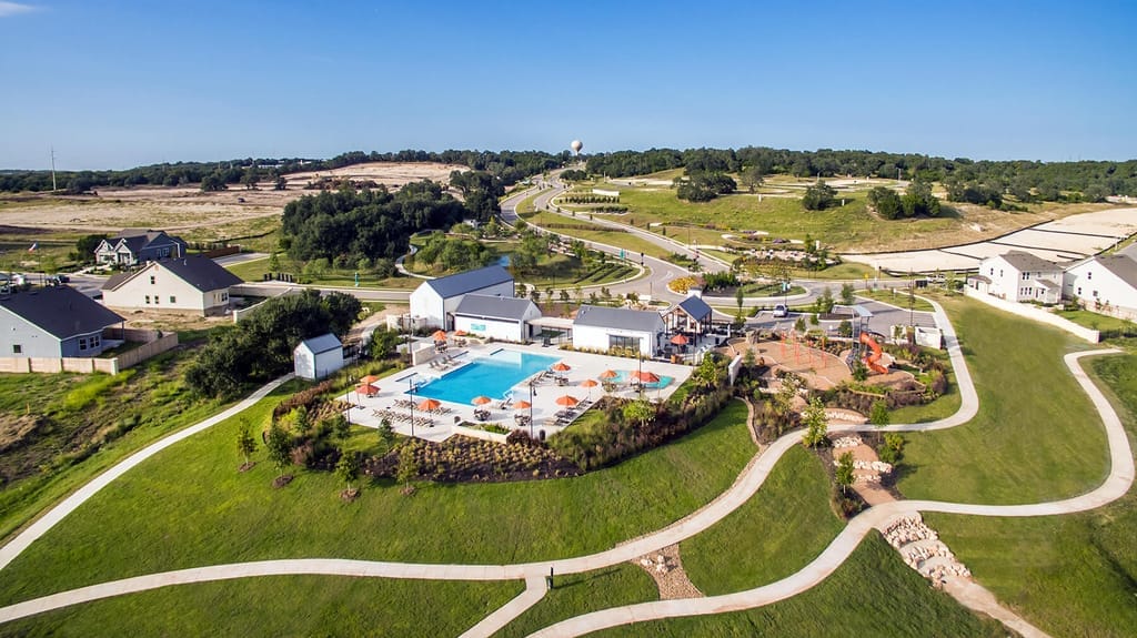 A resort pool and landscaped grounds cut into open Hill Country near Liberty Hill
