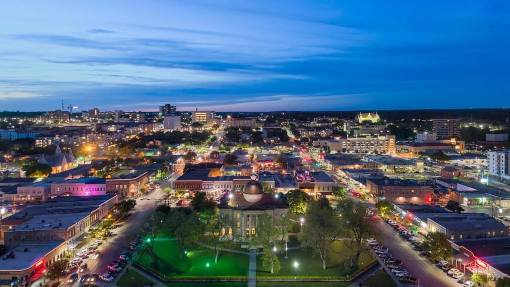 Downtown San Marcos at night from above, lit streets running out from the courthouse square