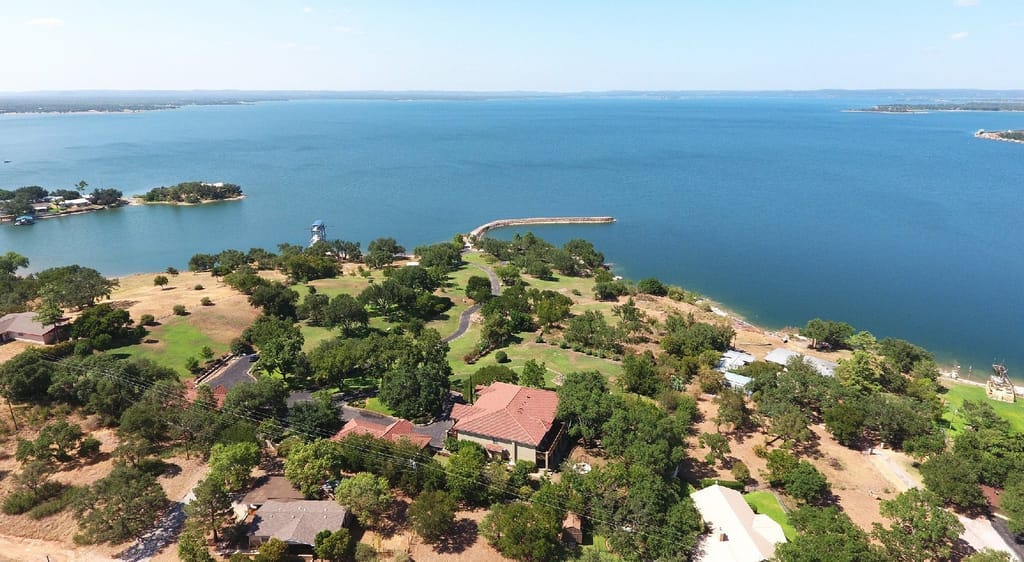 Lake Buchanan from the air, open water to the horizon past lakeside houses and a long pier