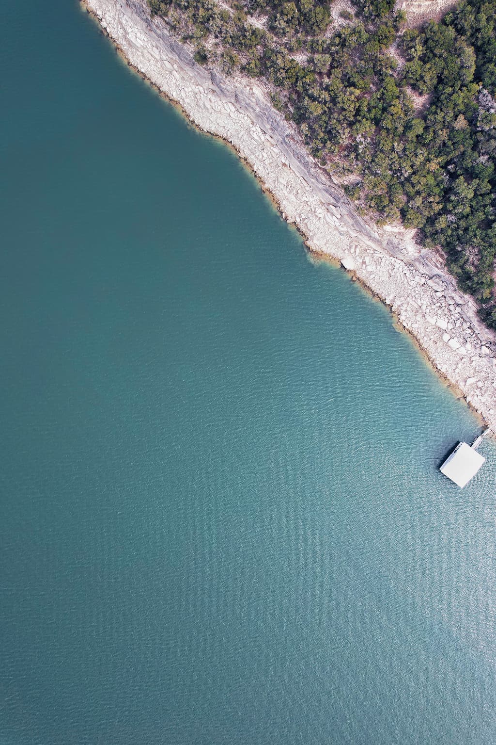 Lake Travis from above, deep blue water between steep cedar-covered slopes