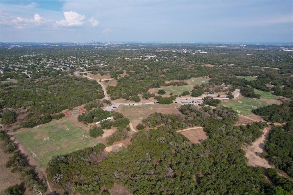 A Circle C Ranch street of two-story homes with the greenbelt beyond